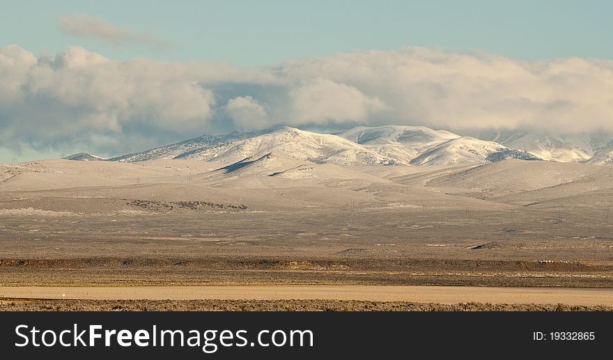 A peaceful cloud hovers above a nice snowy mountain. A peaceful cloud hovers above a nice snowy mountain.