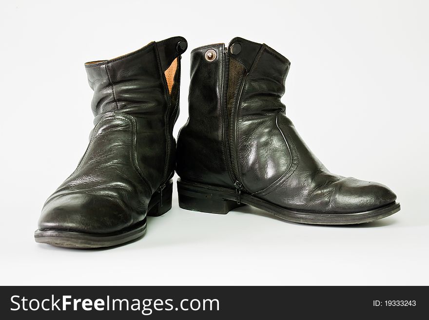 Old black leather boots isolated on white background