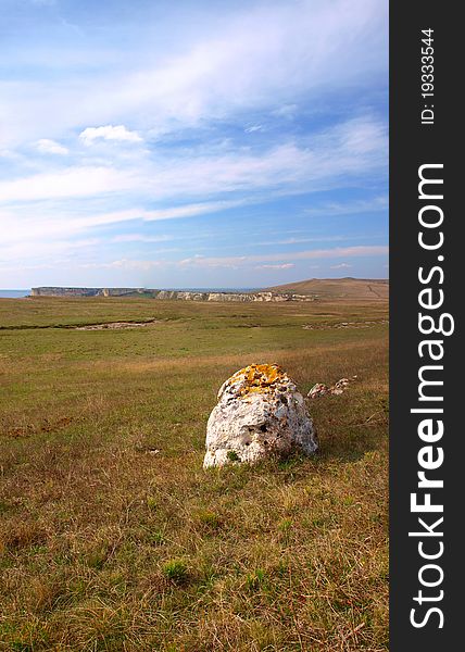 Vertical panorama of a blue cloudy sky, distant mountains and a stone. Crimea, Ukraine. Vertical panorama of a blue cloudy sky, distant mountains and a stone. Crimea, Ukraine