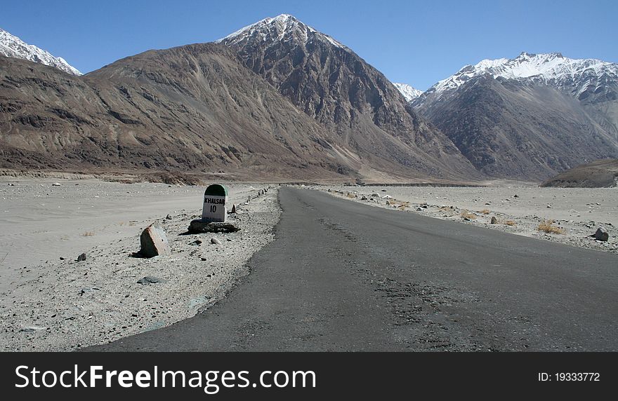 A Lonely Road leading towards a scenic snow clad mountain in the Nubra Valley, Ladakh Region of India