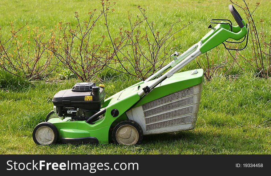 Used lawn mower on fresh cut grass in the garden