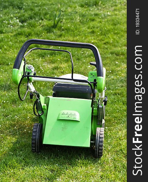 Lawn mower on fresh cut grass in the garden