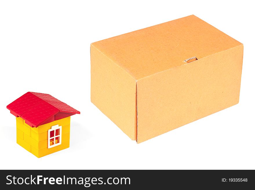 Cardboard box and a toy house with a white background. Cardboard box and a toy house with a white background