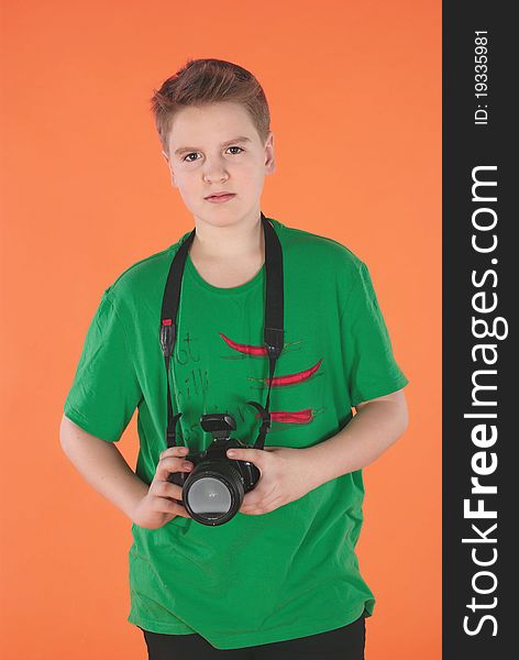Boy with photocamera. Orange background