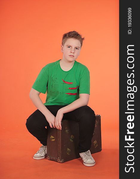 Boy sitting on suitcase