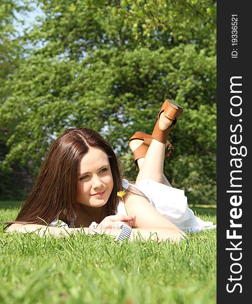 A young lady is lying down on the grass on a beautiful summers day. A young lady is lying down on the grass on a beautiful summers day.