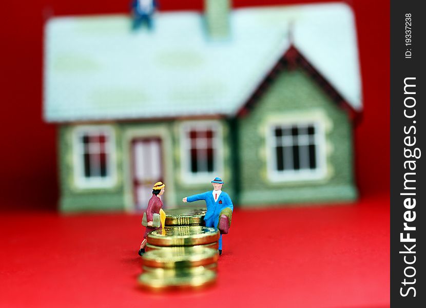 A couple on a staircase of gold coins in the front of a large house in the background on a slight angle with a light pastel red background, asking the question are you on a financial slippery slope.