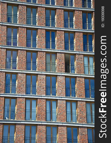 Fragment of the facade of the modern brick residential house with the same balcony. Detail.