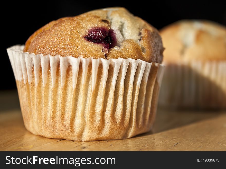 Fresh fruity muffin with muffin in background