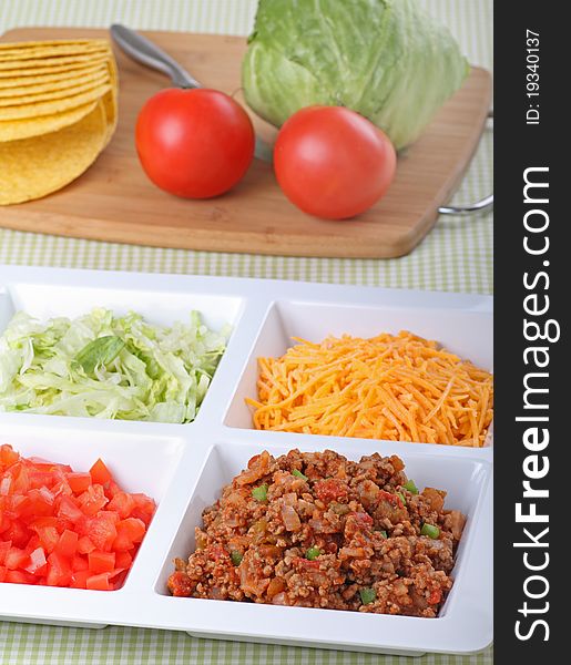 Beef, tomato, lettuce, cheese and shells for making tacos. Beef, tomato, lettuce, cheese and shells for making tacos