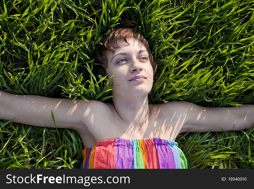 Young woman lying on grass, smiling
