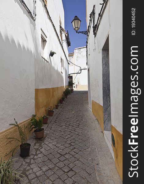 Narrow street in Portugal with whitewashed houses, typical of the south of the Iberian Peninsula.