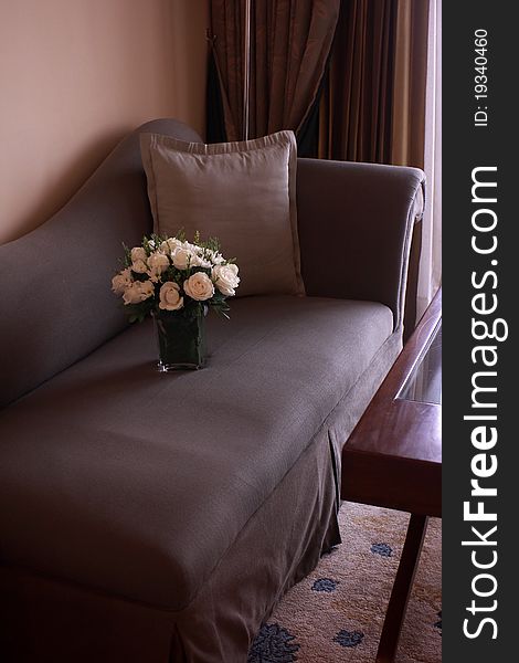 A flower vase on a sofa in a well-furnished room