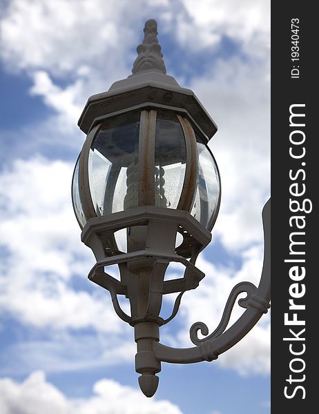 Metal lantern cut against the blue sky with clouds. Metal lantern cut against the blue sky with clouds