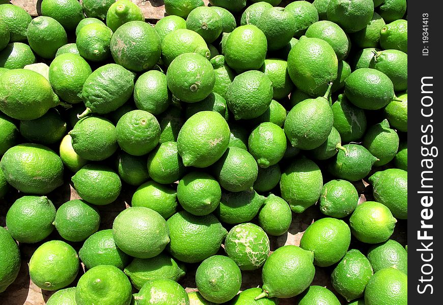 A lot of green limes on a market