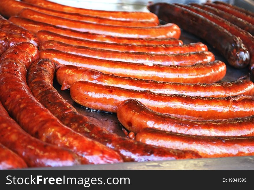 Few red sausages on the hot metal pan