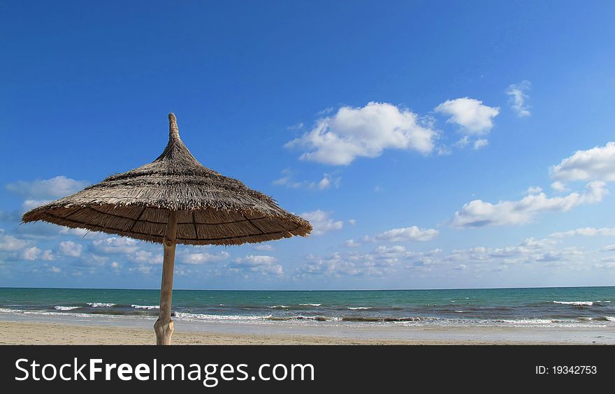 A straw umbrella in a beach resort in Tunesia. A straw umbrella in a beach resort in Tunesia