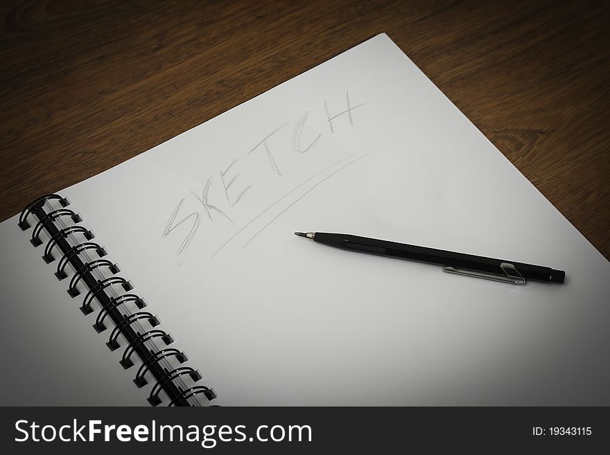 Wire notepad on a wooden desk background. Wire notepad on a wooden desk background
