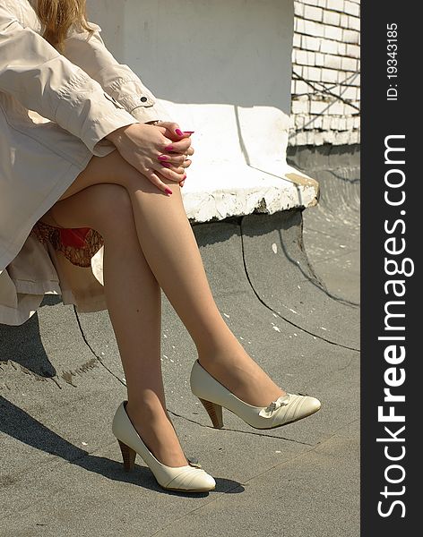 Crossed female legs in beige shoes