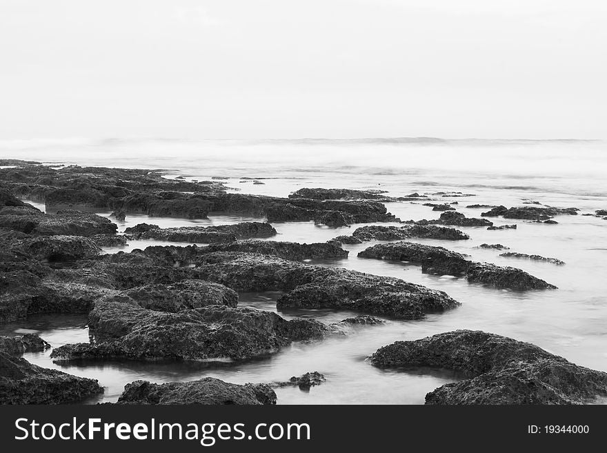 Marine rocks in the surf in the morning mist (Black and white photograph long exposure). Marine rocks in the surf in the morning mist (Black and white photograph long exposure)