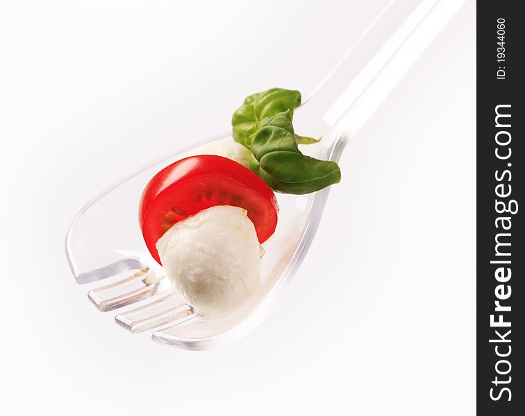 Mozzarella cheese balls and tomato on a salad spoon. Mozzarella cheese balls and tomato on a salad spoon