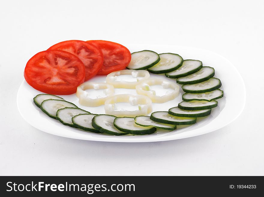 Fresh salad made of tomato, cucumber and paprika on white plate