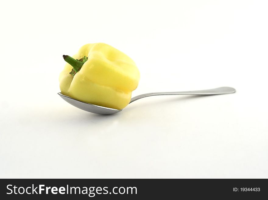 Fresh yellow paprika in a spoon on white background