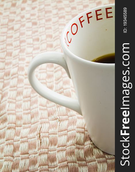 White cup of coffee on weaved brown cloth. White cup of coffee on weaved brown cloth