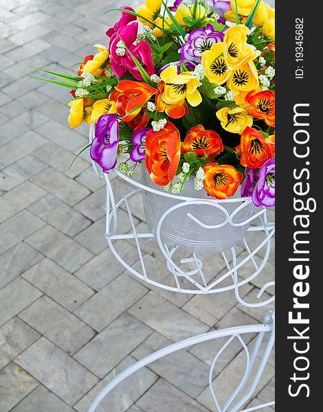 Colorful artificial flower in the bicycle's basket model. Colorful artificial flower in the bicycle's basket model