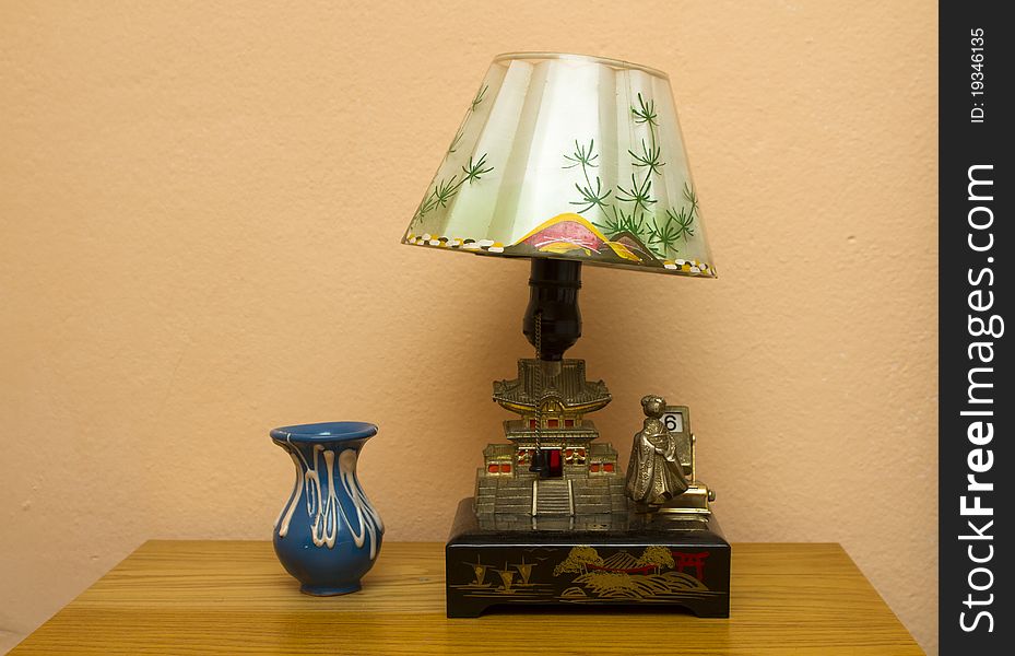 Retro table lamp in oriental style and vase on the bedside table. Retro table lamp in oriental style and vase on the bedside table