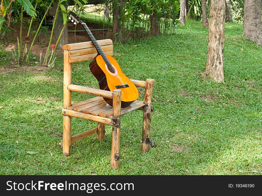 Acoustic Guitar on old rocking chair on grass