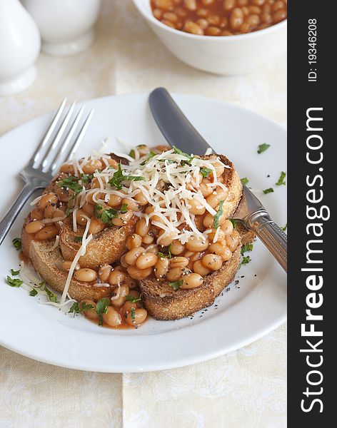 Toasted bread topped with baked beans and grated cheese. Toasted bread topped with baked beans and grated cheese