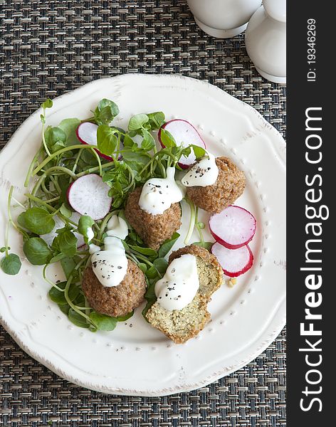 Falafels with radish and watercress on a plate