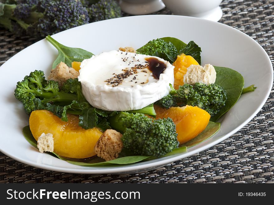 Broccoli, peach and goat's cheese salad in a bowl. Broccoli, peach and goat's cheese salad in a bowl