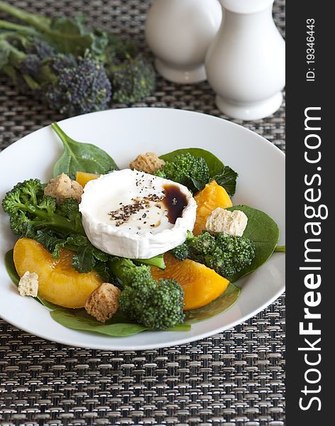 Broccoli, peach and goat's cheese salad in a bowl. Broccoli, peach and goat's cheese salad in a bowl