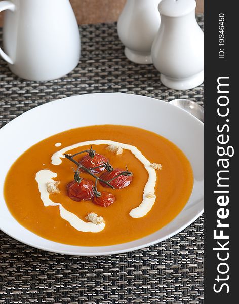 Cream of tomato soup with roasted vine tomatoes in a plate