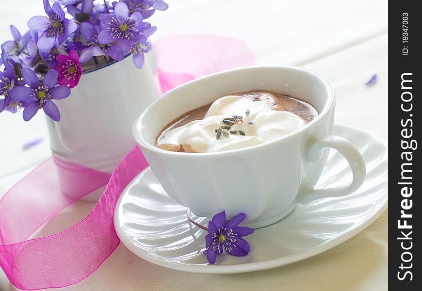 A cup of morning drink with whipped cream and lavender