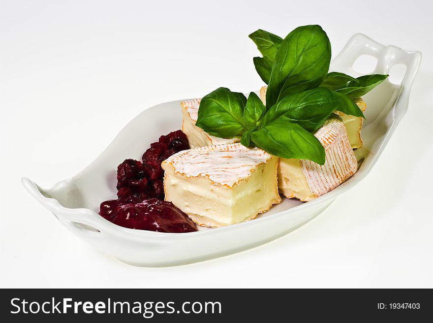 Soft ripened cheese with cumberland sauce and basil leaves