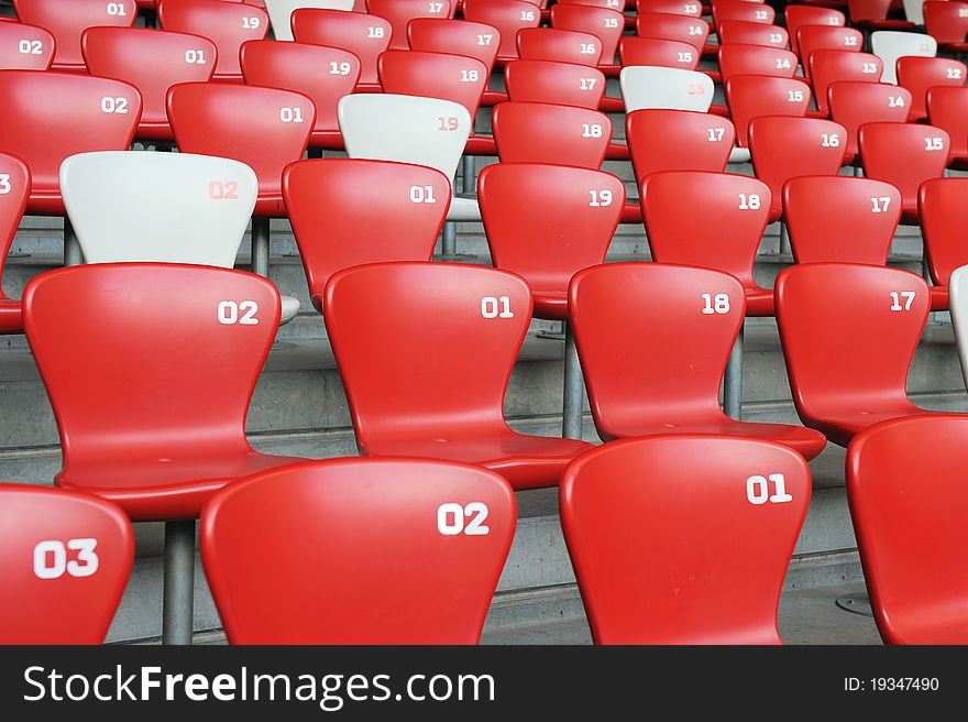 A red and white chair with number array in stadium. A red and white chair with number array in stadium.