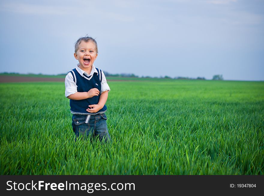 A beautiful little baby boy staing in the grass