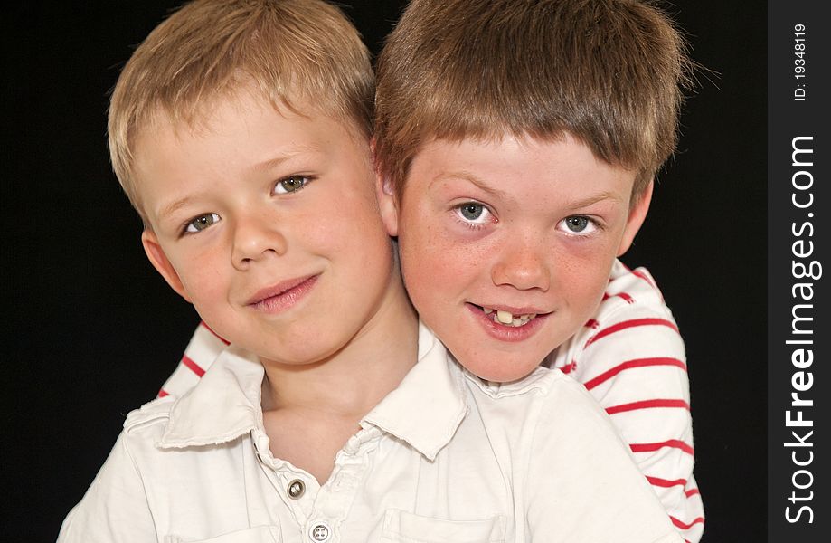 Two Adorable young brothers isolated on a black background