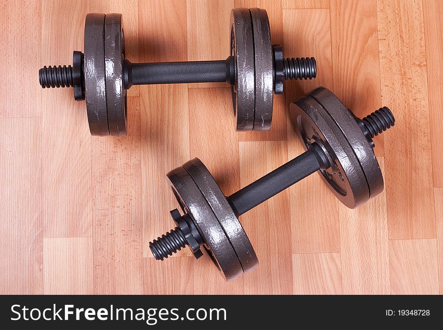 Two heavy dumbbells on a floor