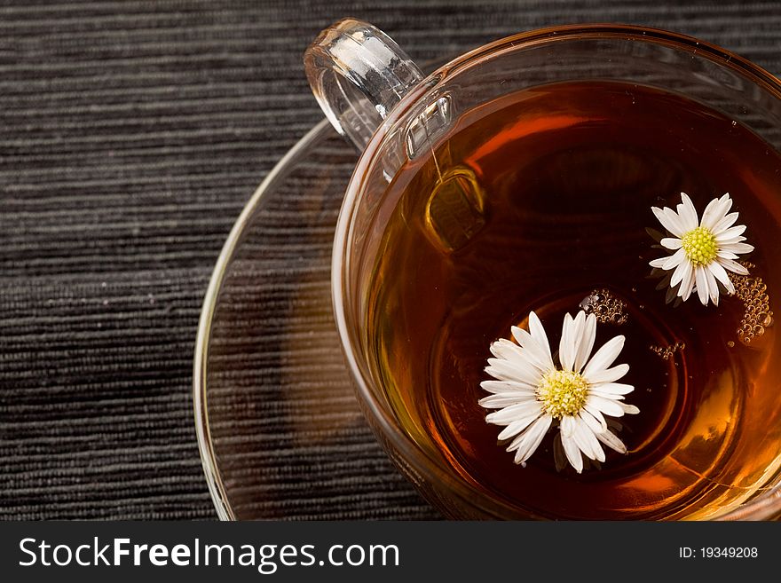 Photo of delicious chamomile tea with marguerite reflecting on the tea. Photo of delicious chamomile tea with marguerite reflecting on the tea
