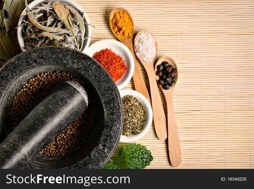 Different spices with wooden spoons and mortar