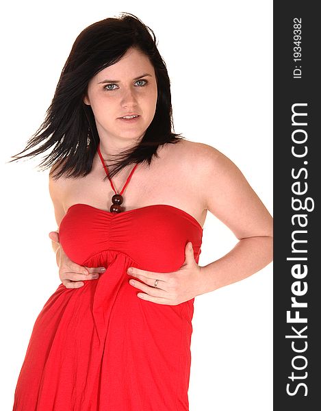 A beautiful young woman in a red dress standing in the studio and her black hair is blowing away, for white background. A beautiful young woman in a red dress standing in the studio and her black hair is blowing away, for white background.