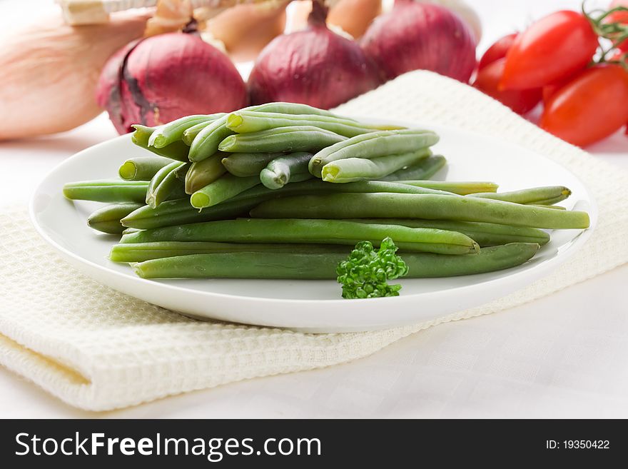 Photo of french beans on white isolated background with different vegetables around. Photo of french beans on white isolated background with different vegetables around