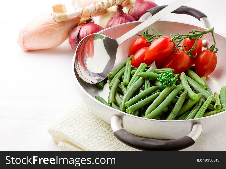 Photo of french beans inside a pan with cherry tomatoes