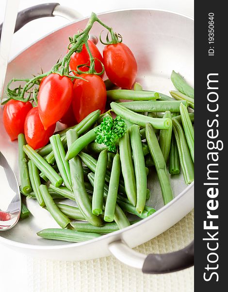 Photo of french beans inside a pan with cherry tomatoes