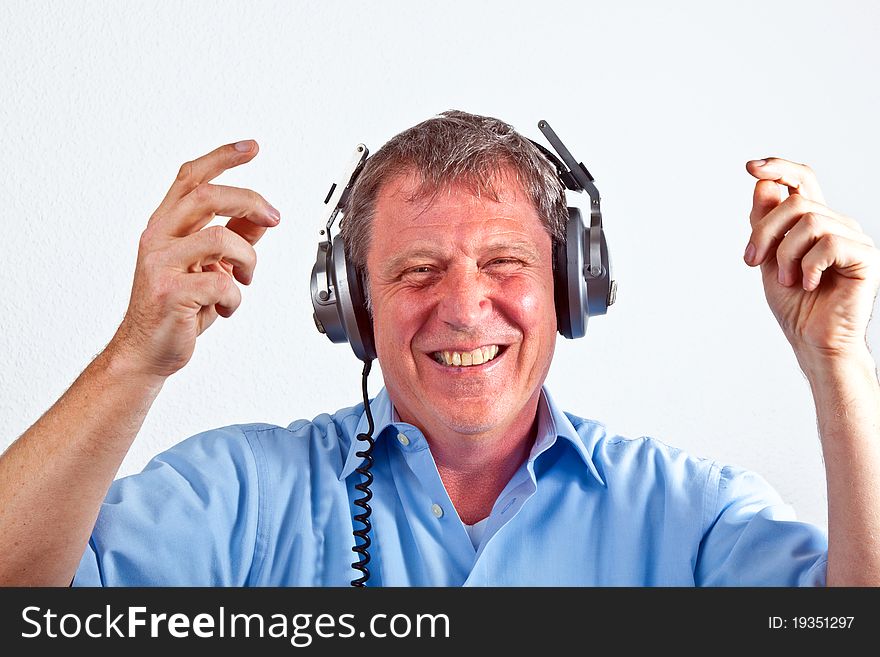 Happy man enjoys music with the headphones