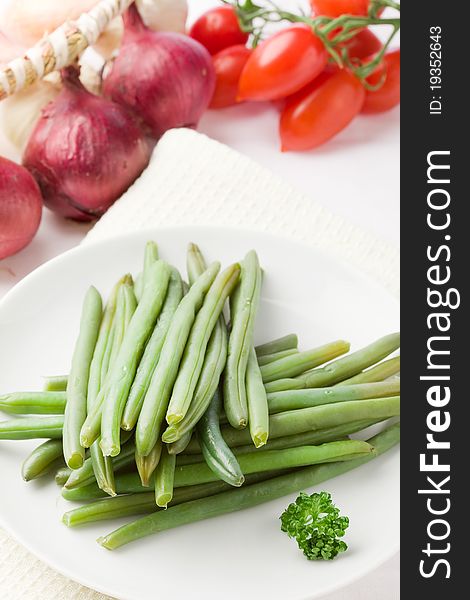 Photo of french beans on white isolated background with different vegetables around. Photo of french beans on white isolated background with different vegetables around